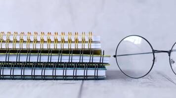 A pair of glasses and a stack of notebooks video