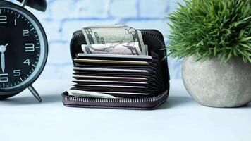A wallet with money and a clock video