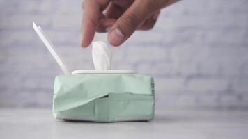 A person is holding a tissue in front of a green box video