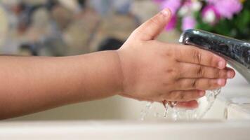 A child's hand is washing under a faucet video