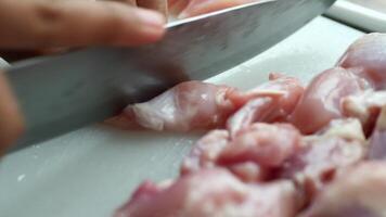 A person cutting up raw chicken on a cutting board video