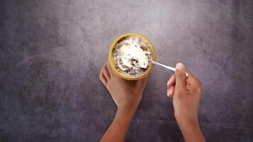 A person holding a spoon over a bowl of ice cream video