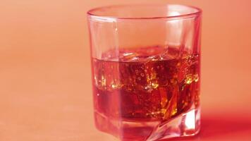 A glass of whiskey on a red background video