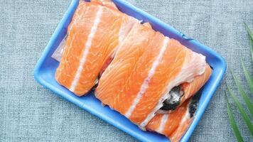 Raw salmon fillet in blue container on gray background video