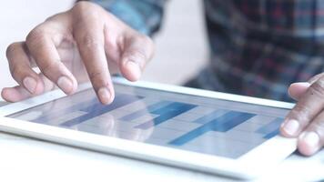 A person is using a tablet computer with a bar chart video