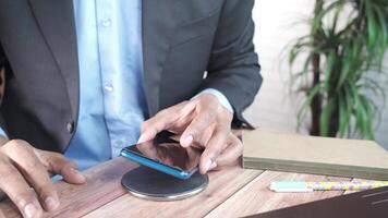 A man in a suit is using his phone on a table video