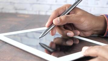 A person is using a pen on a tablet computer video