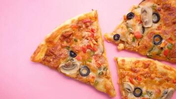 Three slices of pizza with olives and mushrooms on a pink background video