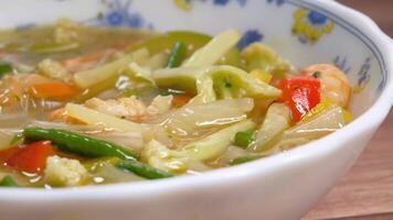 A bowl of soup with vegetables and meat in it video