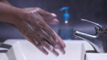 A person washing their hands in a bathroom sink video