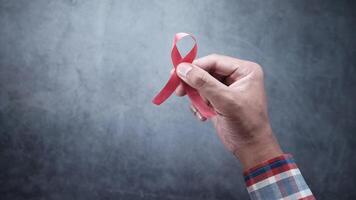 A person holding a red ribbon in their hand video