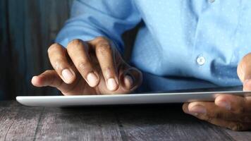 A person is using a tablet computer on a wooden table video