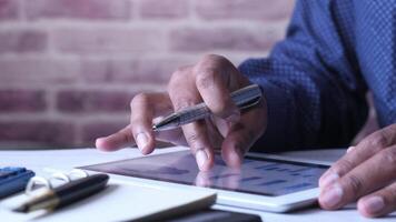 A person is using a pen and tablet on a desk video