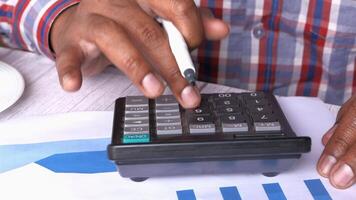 A man using a calculator to make a financial decision video