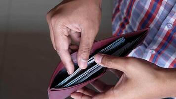 A person holding a wallet with a credit card in it video