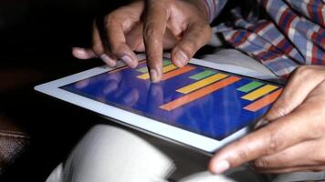 A man is using an ipad to play a game video