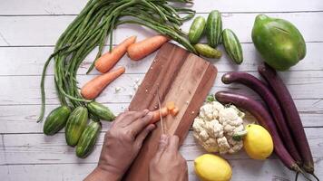 A person cutting vegetables on a wooden cutting board video