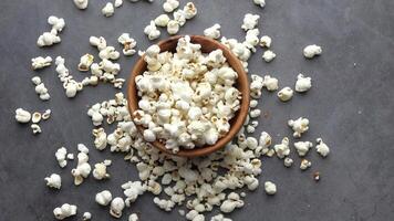 A bowl of popcorn on a table with a spoon video