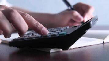 A person is using a calculator on a desk video