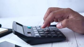 A person is using a calculator on a desk video