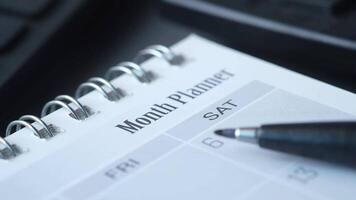 Month planner on desk with pen video