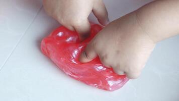 A child's hand is touching a red plastic toy video