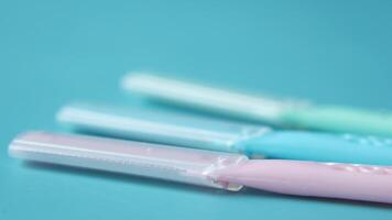 A close up of three toothbrushes on a blue surface video