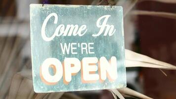 Come in we're open sign hanging on a window video