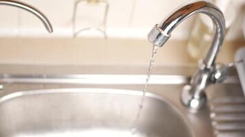 A kitchen sink with a faucet running water video