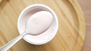 A spoonful of yogurt is being held up in front of a bowl video