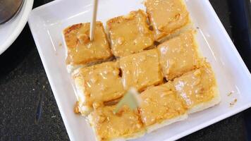 A square of food on a plate with a toothpick video