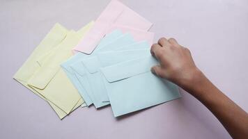 A person holding a stack of envelopes on a pink background video