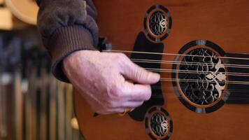 A CloseUp View of a Person Skillfully Playing a Unique Acoustic Guitar String Instrument video