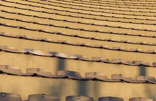 Empty rows of numbered stadium seats, orderly arrangement, venue architecture captured at sunset, seating concept photo