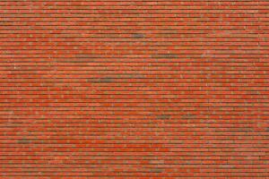Wall of red brick. Designer interior background. Abstract architectural surface. photo