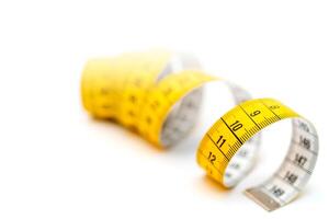 Yellow measuring tape on white background. Measurement of length and circumference. Lose weight and get fat. photo