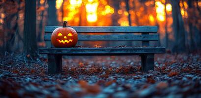 A bench with a pumpkin on it in the woods. The pumpkin is lit up and has a scary face. The scene is set in autumn, with leaves on the ground and a warm glow from the sun. Halloween photo