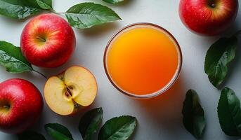 A glass of juice is poured over a bowl of sliced apples photo