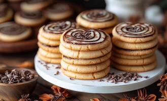 A stack of cookies with chocolate chips and a heart shape on top. The cookies are piled on top of each other and there is a bowl of chocolate chips next to them photo
