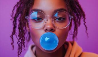 A woman with curly hair is blowing bubbles with a blue bubblegum. The image has a fun and playful mood, as the woman is enjoying a simple and lighthearted activity photo