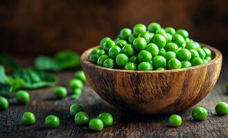 A bowl of green peas is sitting on a wooden table. The peas are fresh and vibrant, and the bowl is filled to the brim. Concept of abundance and health, as peas are a nutritious and versatile vegetable photo