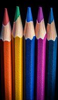 A close up of six colored pencils, each with a different color. The pencils are lined up next to each other, with the blue one in the middle. Concept of creativity and artistic expression photo