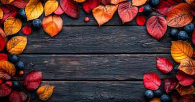A wooden frame with red leaves and blueberries. The frame is empty and the leaves and berries are scattered around it photo