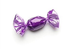 A shiny purple candy, beautifully wrapped, stands out against a clean white background, showcasing a delightful and tempting treat that is visually striking and appealing to the senses photo
