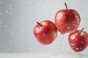 Three apples are being sprayed with water photo