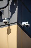 Security Cameras on Building Corner with Strong Shadows in Urban Setting photo