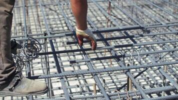 Connecting reinforcement with wire at a construction site video