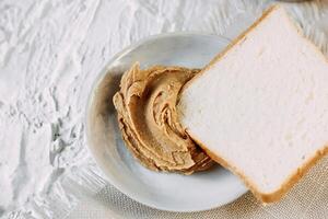 thick peanut butter in a jar close-up. Healthy eating photo