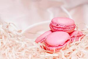 French pink macaroon cookies on silk tablecloth photo