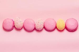 French pink macaroon cookies with Easter decorative eggs. photo